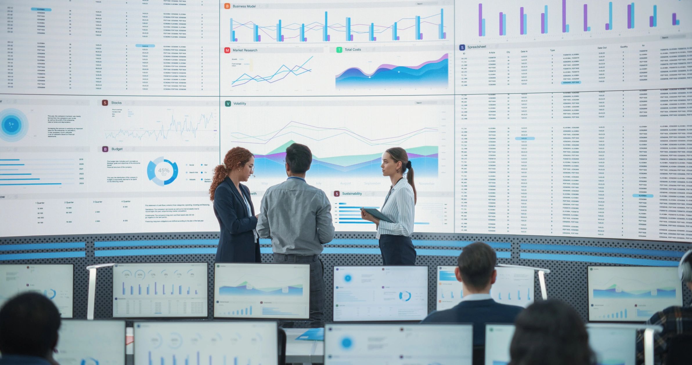 Team reviewing reports and graphs on large digital screen